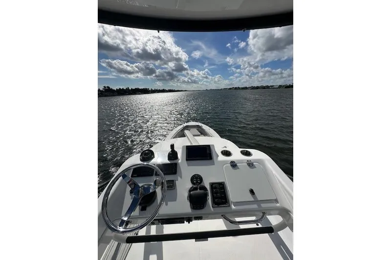 Slide: The Image of 2016 Everglades 435 Center Console boat on open water under a partly cloudy sky. - 18