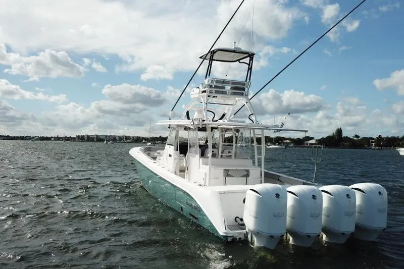 Slide: The Image of 2016 Everglades 435 Center Console boat with four engines on open water. - 2