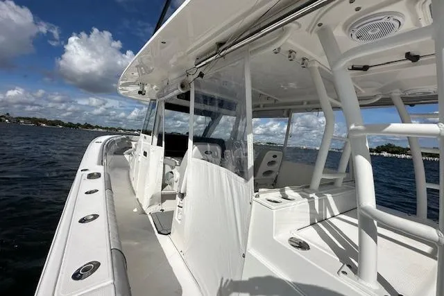 Slide: The Image of 2016 Everglades 435 Center Console boat on water, showcasing sleek design and spacious deck. - 22