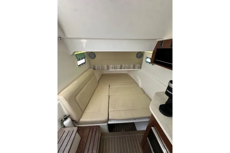 Slide: The Image of Interior cabin of 2016 Everglades 435 Center Console with beige seating and compact amenities. - 25