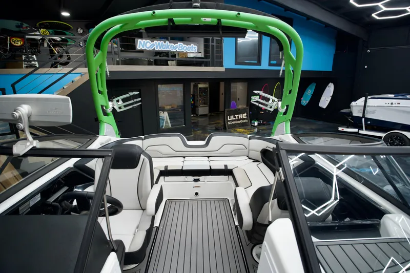 Slide: The Image of 2018 Yamaha Boats 212X interior with green wakeboard tower, showcased in a modern showroom. - 12
