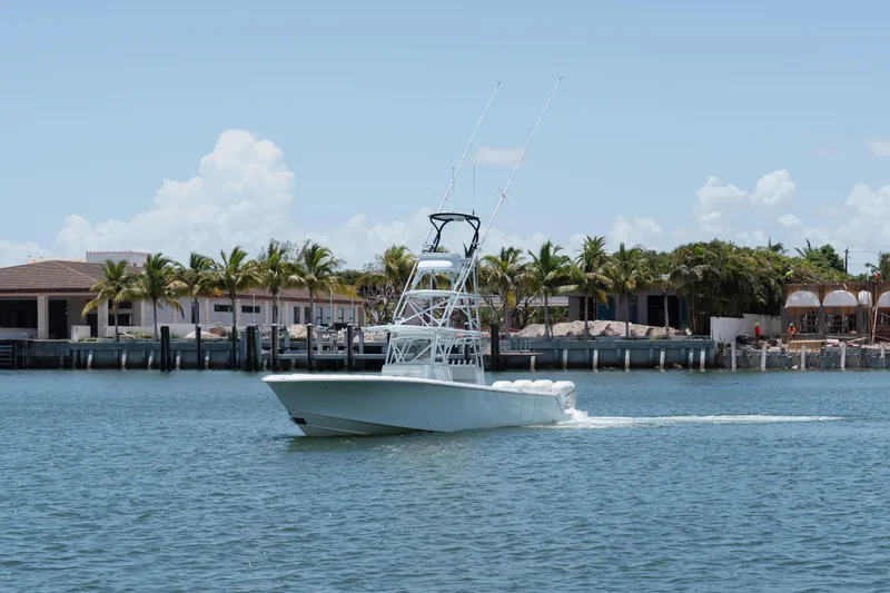 The Image of 2017 SeaVee 390Z boat cruising near waterfront homes and palm trees. - 1