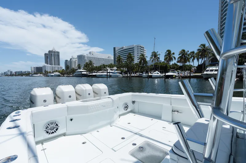 Slide: The Image of 2017 SeaVee 390Z boat with four engines, docked near palm trees and city skyline. - 14