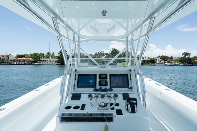 Slide: The Image of 2017 SeaVee 390Z boat console with navigation screens, steering wheel, and waterfront view. - 20