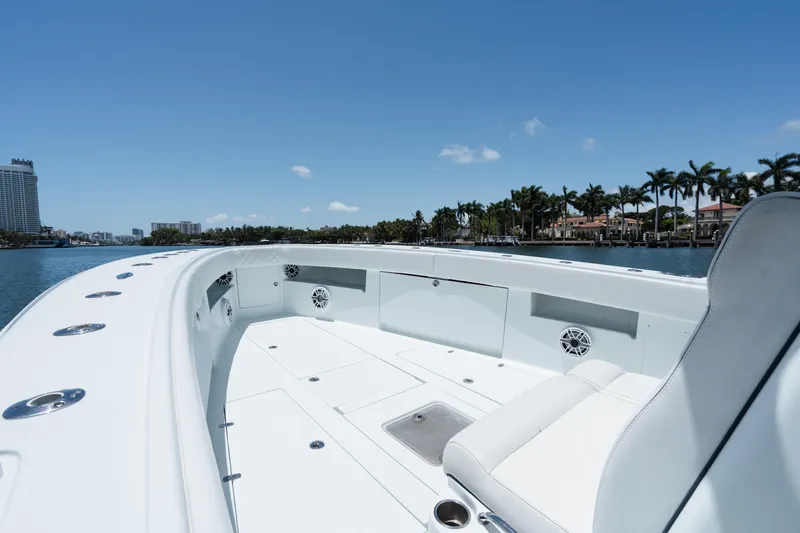 Slide: The Image of 2017 SeaVee 390Z boat interior with seating, on a sunny day near waterfront homes. - 7