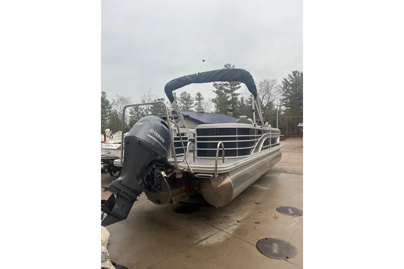 Slide: The Image of 2022 Bennington 25 LSR pontoon boat with Yamaha outboard motor, parked outdoors. - 11
