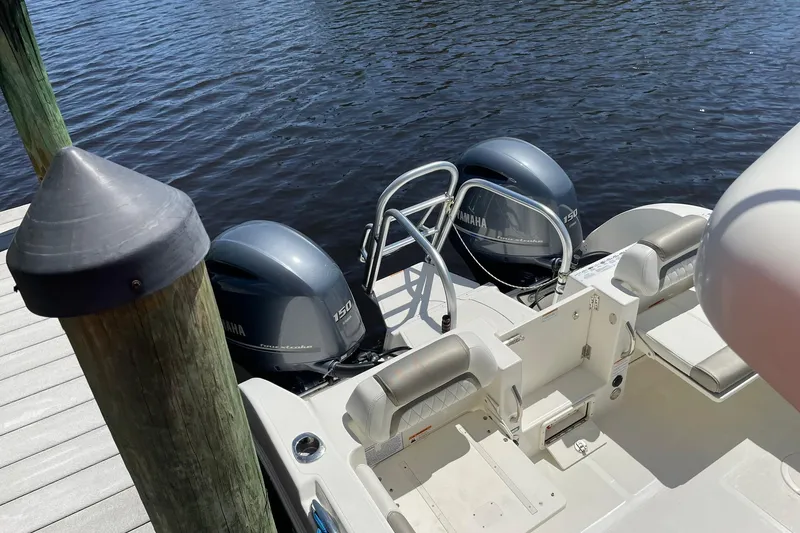 Slide: The Image of 2022 World Cat 255 DC boat with twin Yamaha 150 engines docked by water. - 3