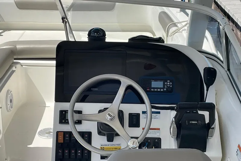 Slide: The Image of 2022 World Cat 255 DC boat dashboard with steering wheel and navigation controls. - 5