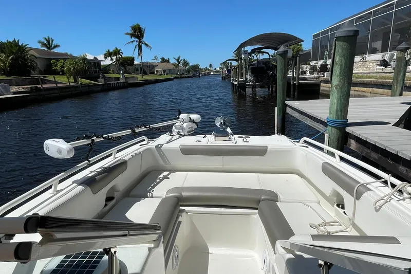 Slide: The Image of 2022 World Cat 255 DC boat docked in a sunny canal with palm trees. - 9