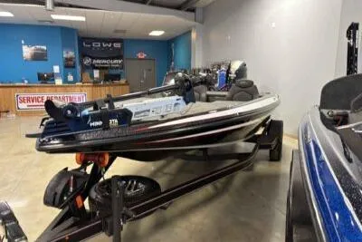 Slide: The Image of 2026 Skeeter ZX150 bass boat displayed in showroom with service department in background. - 5