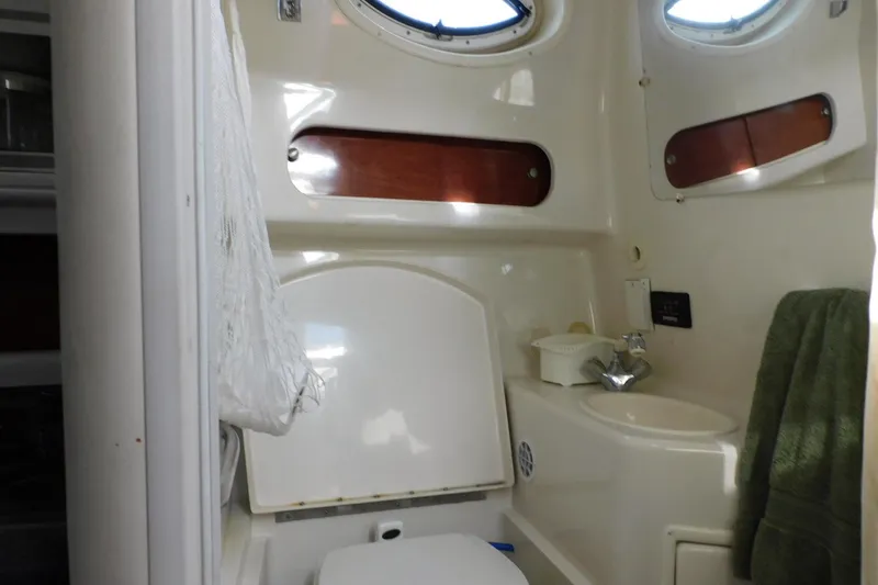 Slide: The Image of Bathroom interior of a 2006 Monterey 302 Cruiser boat, featuring sink and portholes. - 10