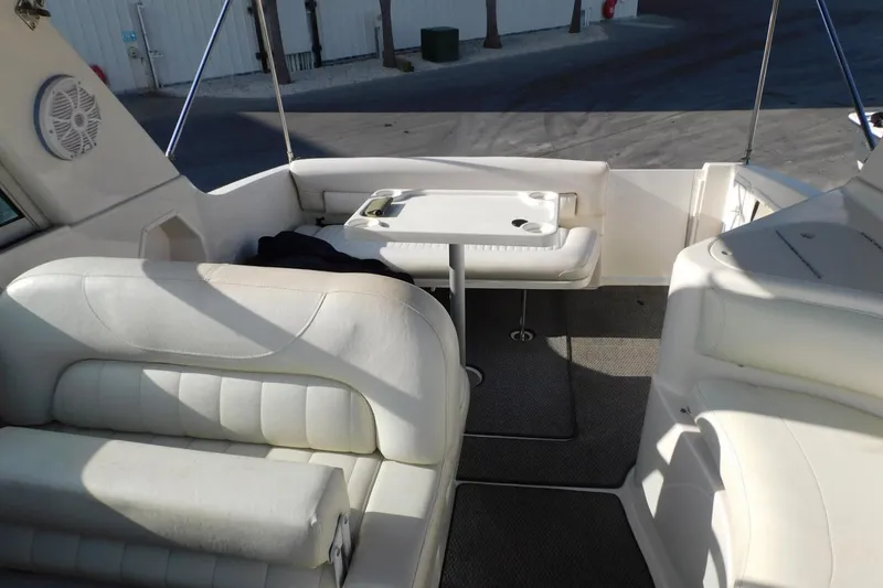 Slide: The Image of Interior of a 2006 Monterey 302 Cruiser boat with white seating and table. - 17