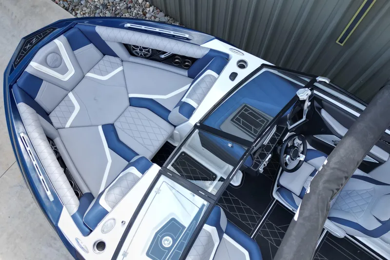 Slide: The Image of 2019 Tigé ZX1 boat interior with blue and gray seating, modern design, and steering wheel. - 5