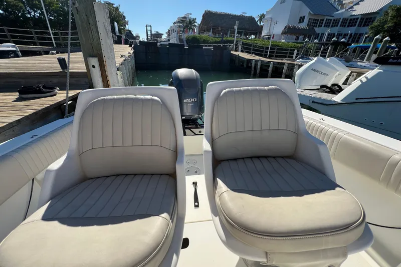 Slide: The Image of 2004 Hydra-Sports 212 CC boat interior with twin seats and docked view. - 13