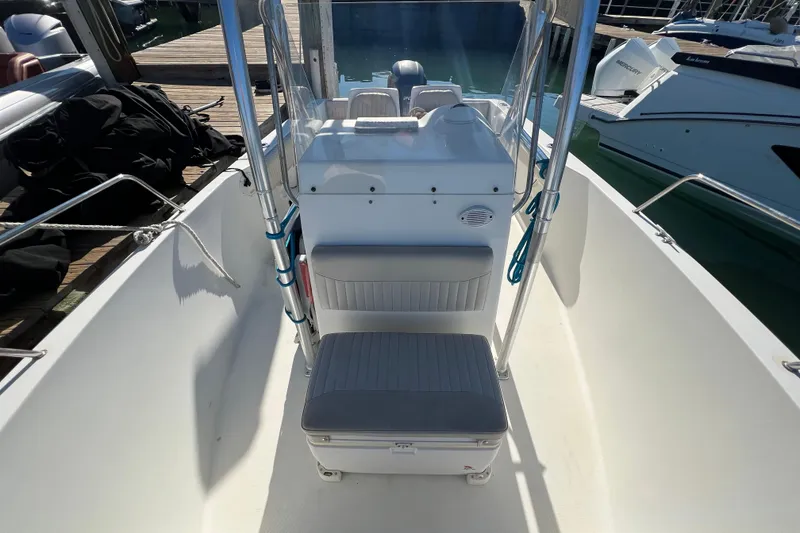 Slide: The Image of 2004 Hydra-Sports 212 CC boat interior with seating and console, docked at marina. - 16