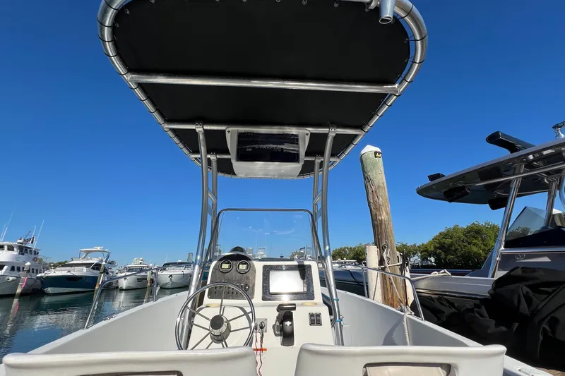 Slide: The Image of 2004 Hydra-Sports 212 CC boat at marina, featuring steering console and canopy. - 18