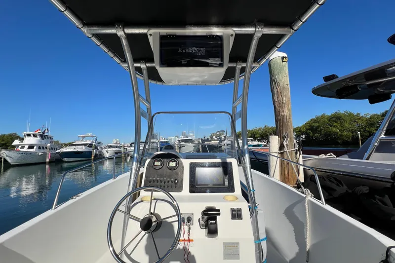 Slide: The Image of 2004 Hydra-Sports 212 CC boat dashboard with steering wheel, docked in a marina. - 19