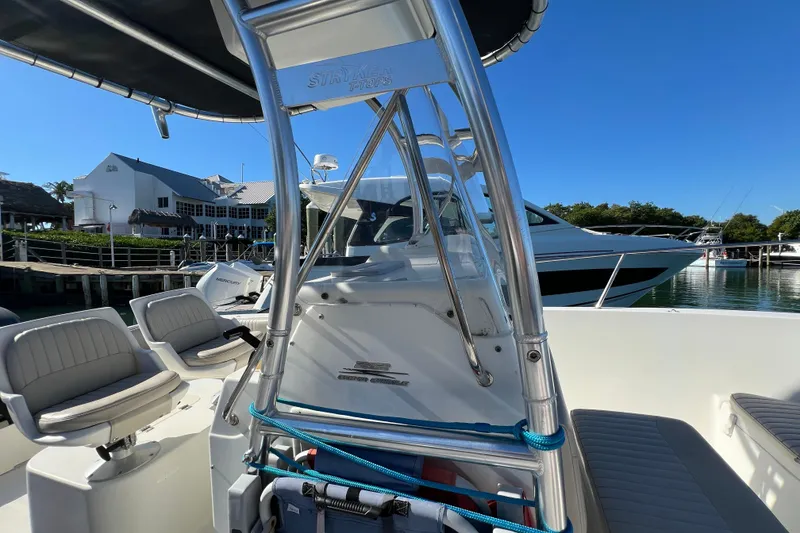 Slide: The Image of 2004 Hydra-Sports 212 CC boat interior with seating and T-top, docked at marina. - 20