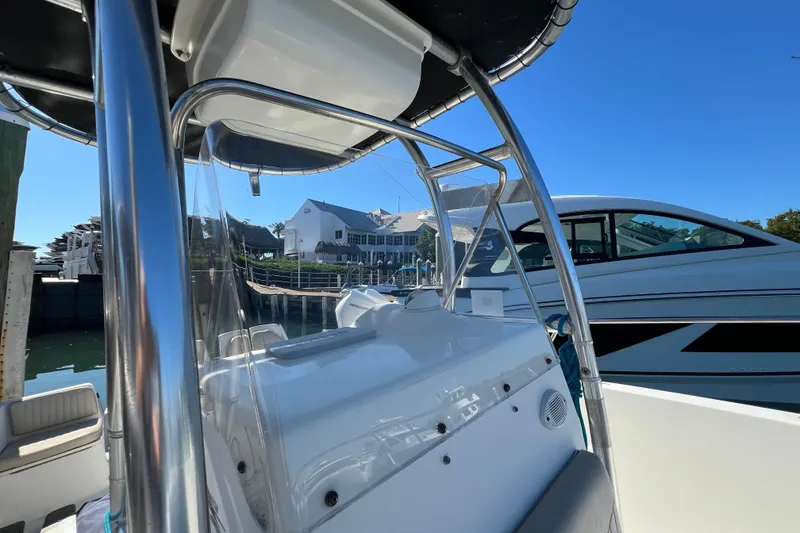 Slide: The Image of 2004 Hydra-Sports 212 CC boat docked at marina under clear blue sky. - 21