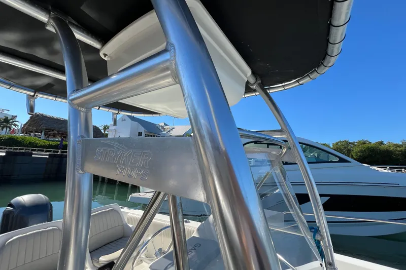 Slide: The Image of 2004 Hydra-Sports 212 CC boat with Stryker T-Top, docked under clear blue sky. - 22