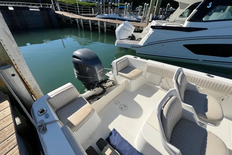 Slide: The Image of 2004 Hydra-Sports 212 CC boat docked, featuring spacious seating and a powerful outboard motor. - 24