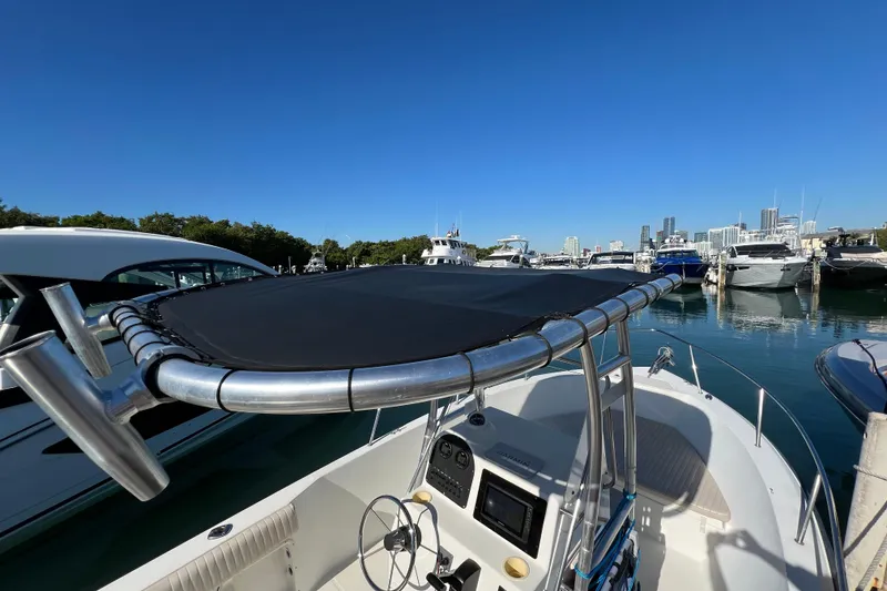 Slide: The Image of 2004 Hydra-Sports 212 CC boat docked in a marina with city skyline. - 25