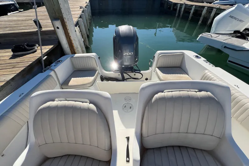 Slide: The Image of 2004 Hydra-Sports 212 CC boat interior with seating and outboard motor at dock. - 27
