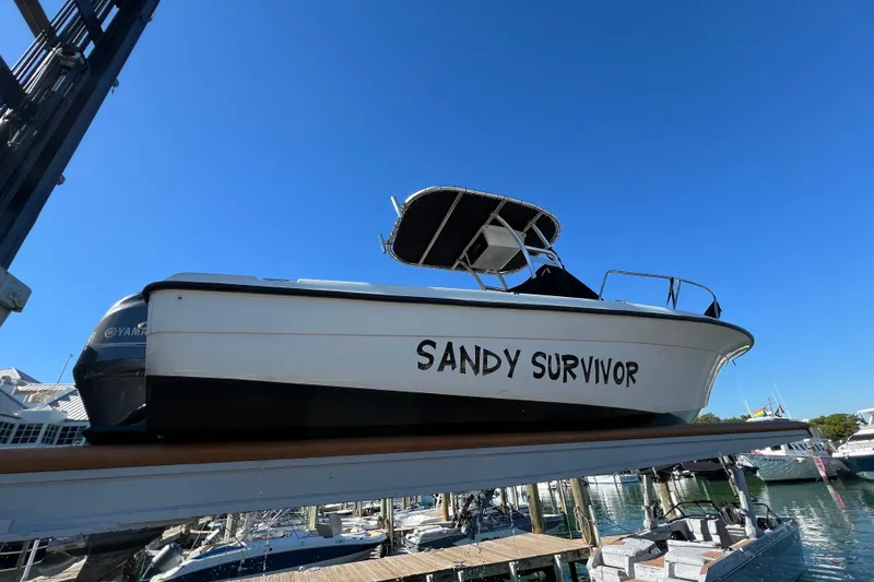 Slide: The Image of 2004 Hydra-Sports 212 CC boat named "Sandy Survivor" docked under clear blue sky. - 33