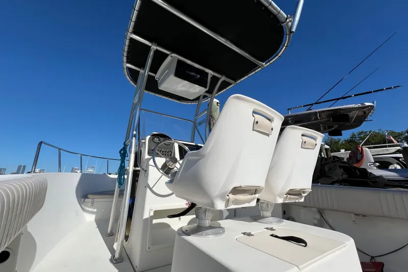 Slide: The Image of 2004 Hydra-Sports 212 CC boat interior with seating and steering console under clear blue sky. - 38