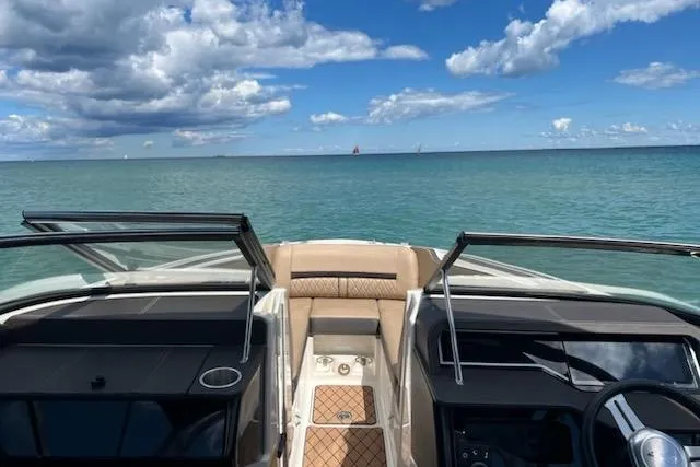 Slide: The Image of 2018 Sea Ray SLX-W 230 boat interior with ocean view under a partly cloudy sky. - 11