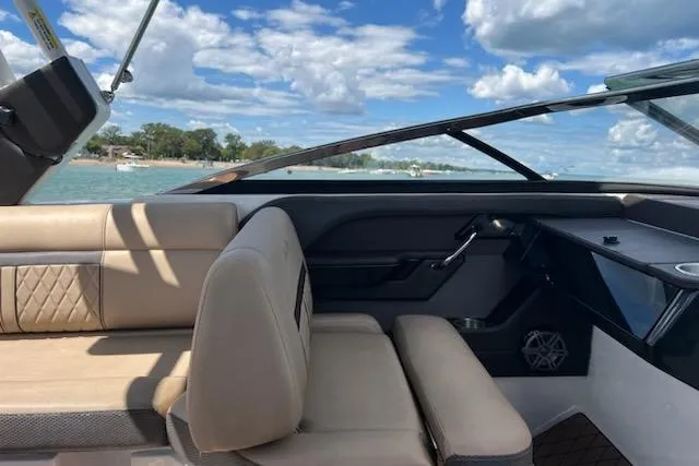 Slide: The Image of 2018 Sea Ray SLX-W 230 boat interior with beige seating, on a sunny day. - 14
