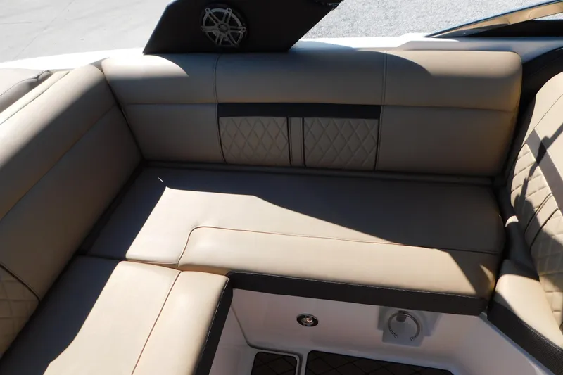 Slide: The Image of 2018 Sea Ray SLX-W 230 boat interior with beige leather seating and speaker detail. - 23