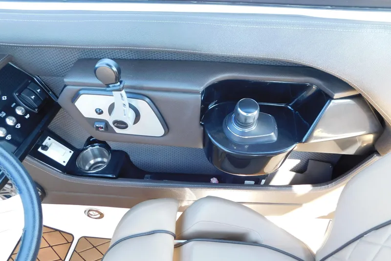 Slide: The Image of 2018 Sea Ray SLX-W 230 boat interior dashboard with controls and cup holder. - 26