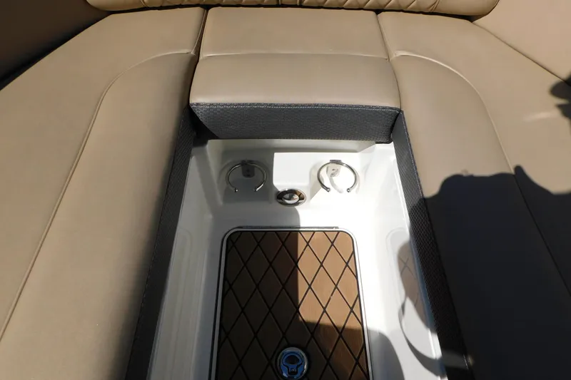 Slide: The Image of 2018 Sea Ray SLX-W 230 boat interior storage compartment with beige seating. - 33