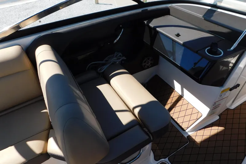 Slide: The Image of 2018 Sea Ray SLX-W 230 boat interior with beige seating and black dashboard. - 42