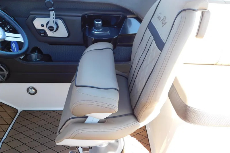 Slide: The Image of 2018 Sea Ray SLX-W 230 boat interior with beige captain's chair and control panel. - 52
