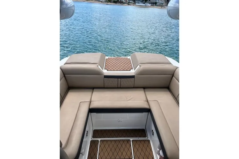 Slide: The Image of 2018 Sea Ray SLX-W 230 boat interior with tan seating, overlooking serene water. - 7