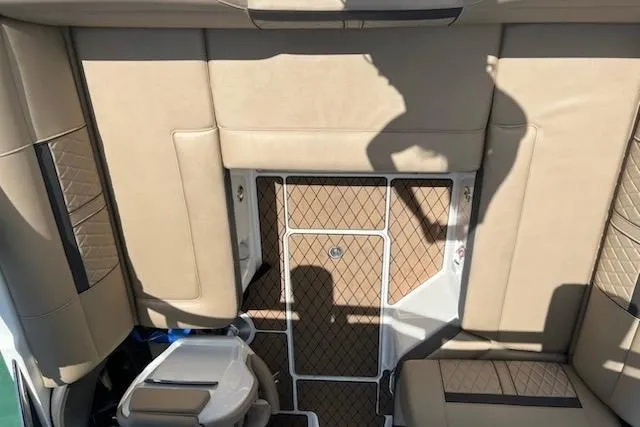 Slide: The Image of 2018 Sea Ray SLX-W 230 boat interior with tan upholstery and patterned flooring. - 8