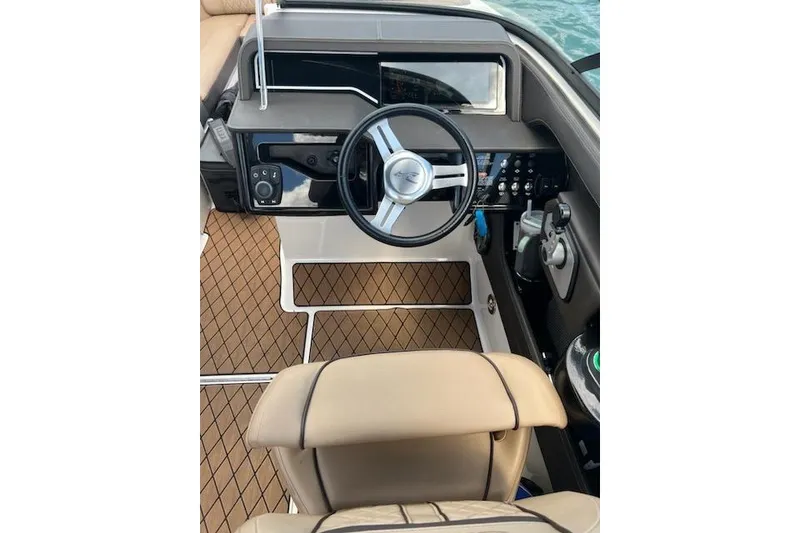 Slide: The Image of 2018 Sea Ray SLX-W 230 boat cockpit with steering wheel and control panel. - 9