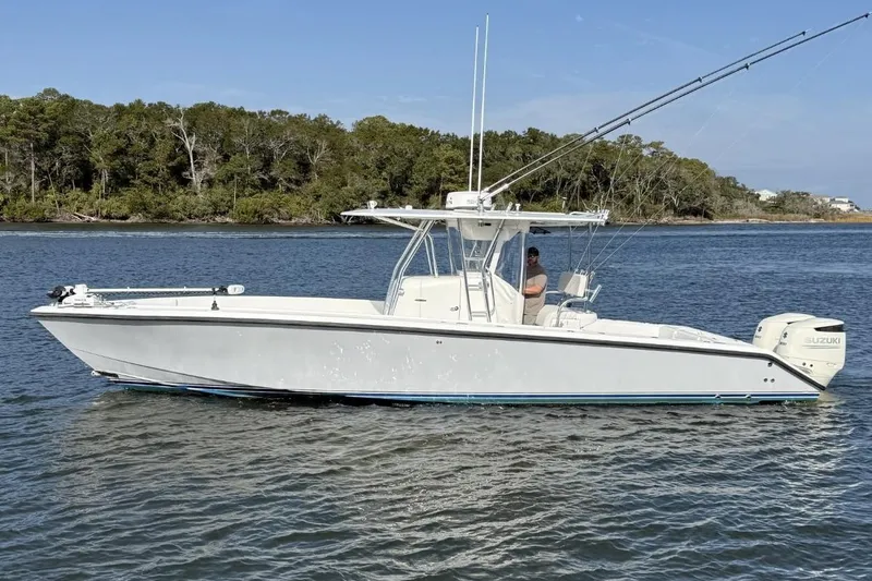 The Image of 1999 Venture 34 Open boat on calm water with trees in the background. - 0
