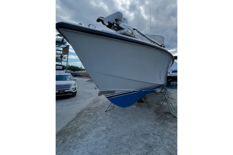 Slide: The Image of 1999 Venture 34 Open boat on stands, cloudy sky background. - 10
