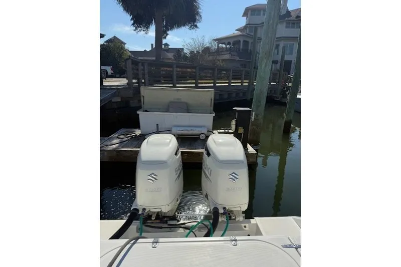 Slide: The Image of 1999 Venture 34 Open boat with dual Suzuki outboard motors docked at marina. - 11