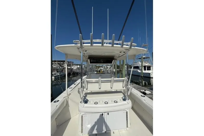 Slide: The Image of 1999 Venture 34 Open boat with rod holders, docked at a marina under clear blue skies. - 2