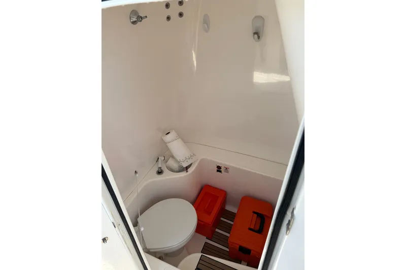 Slide: The Image of 1999 Venture 34 Open boat bathroom with toilet, storage boxes, and paper holder. - 8