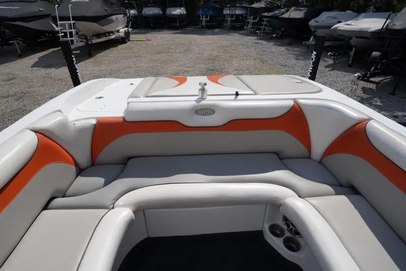 Slide: The Image of 2008 Tigé 24Ve boat interior with orange and white seating, parked in a lot. - 10