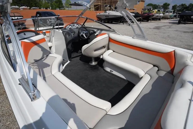 Slide: The Image of 2008 Tigé 24Ve boat interior with orange and white seating, steering wheel, and dashboard. - 8