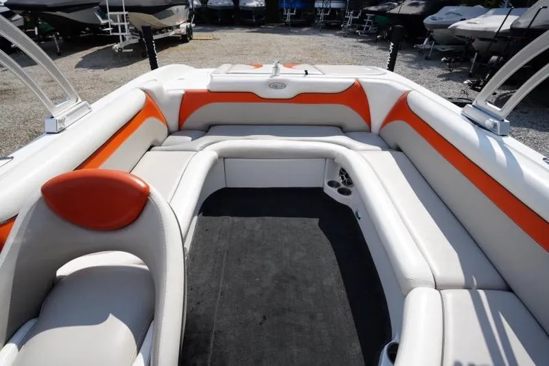 Slide: The Image of 2008 Tigé 24Ve boat interior with orange and white seating, docked outdoors. - 9