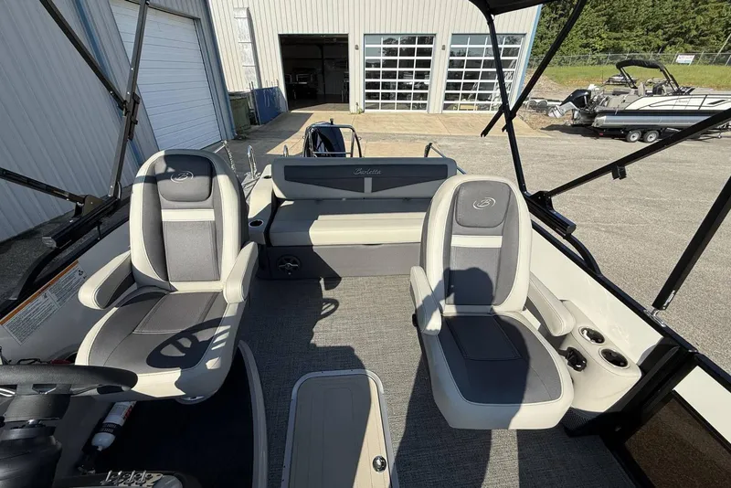 Slide: The Image of 2025 Barletta Cabrio 22UC interior with seating and steering wheel, parked near a garage. - 19