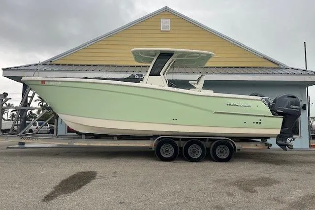 The Image of 2023 World Cat 280 CC-X boat on trailer, parked in front of a building. - 1