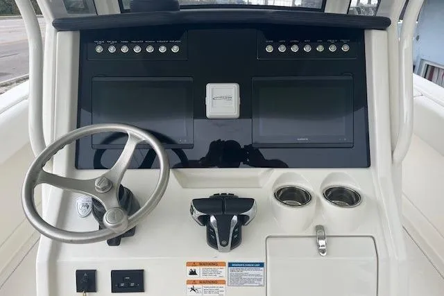Slide: The Image of 2023 World Cat 280 CC-X boat dashboard with dual screens and steering wheel. - 3